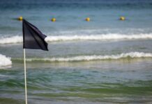 Schwarze Flagge Spanien Strand